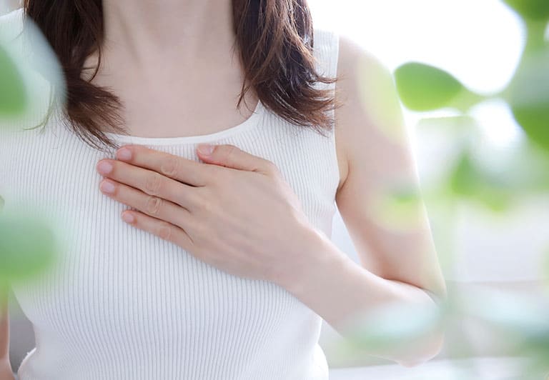 胸に手をあてる女性